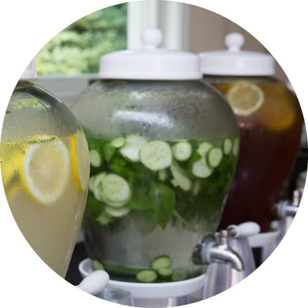 Close up view of drink dispensers including lemonade, cucumber water and iced tea.